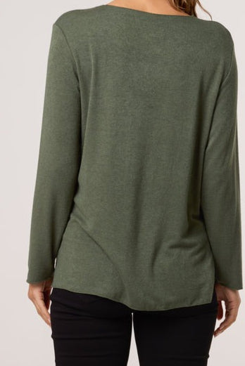 Green long-sleeve top worn by a person on a plain background