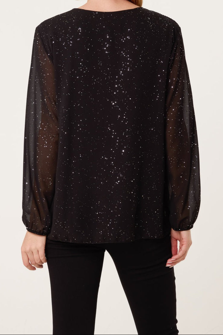 Black sheer blouse with speckled pattern worn by a person on a white background