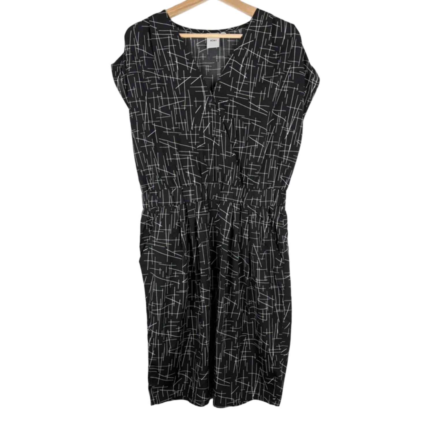 Black dress with white geometric pattern on a hanger against a white background