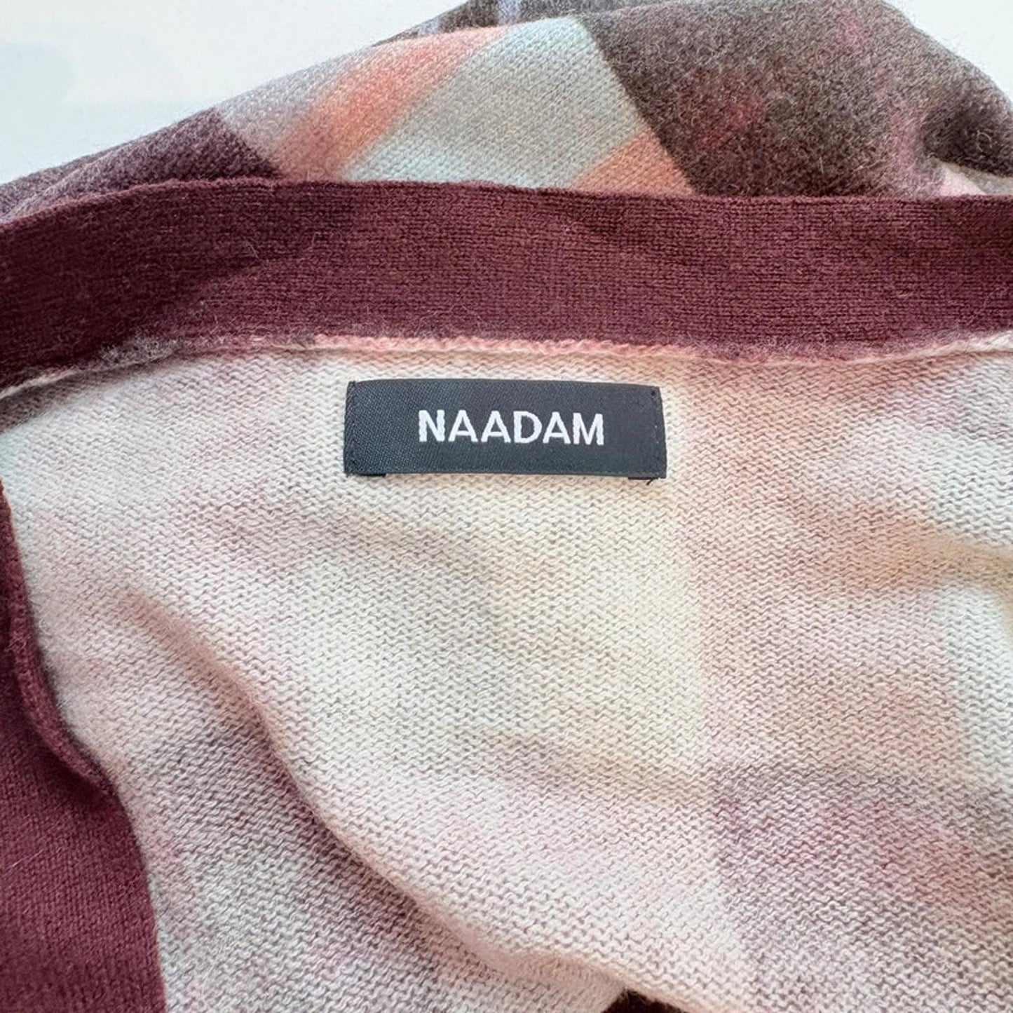 Plaid fabric with a 'NAADAM' label on a white background
