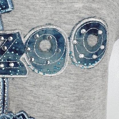 Gray fabric with blue embroidered designs and embellishments