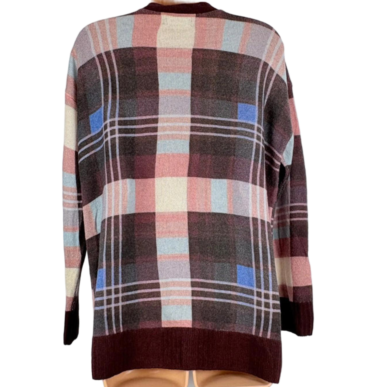 Plaid sweater on a hanger against a white background