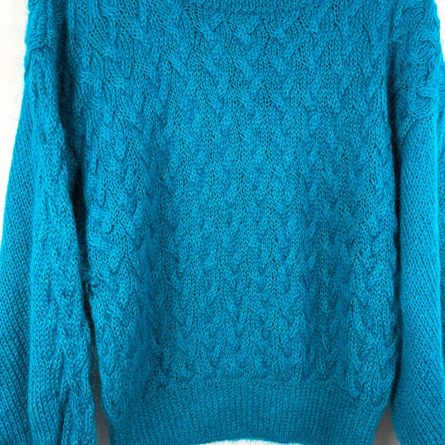 Teal knitted sweater on a white background