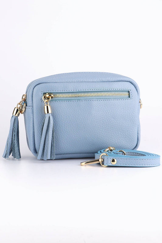 Light blue handbag with a gold zipper and tassel on a white background