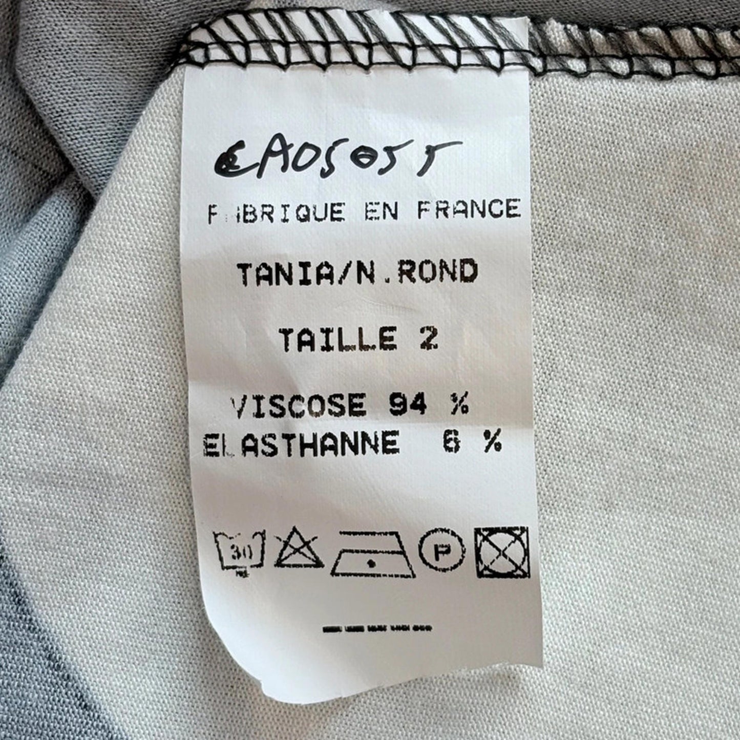 Fabric label with text and symbols on a textured fabric background