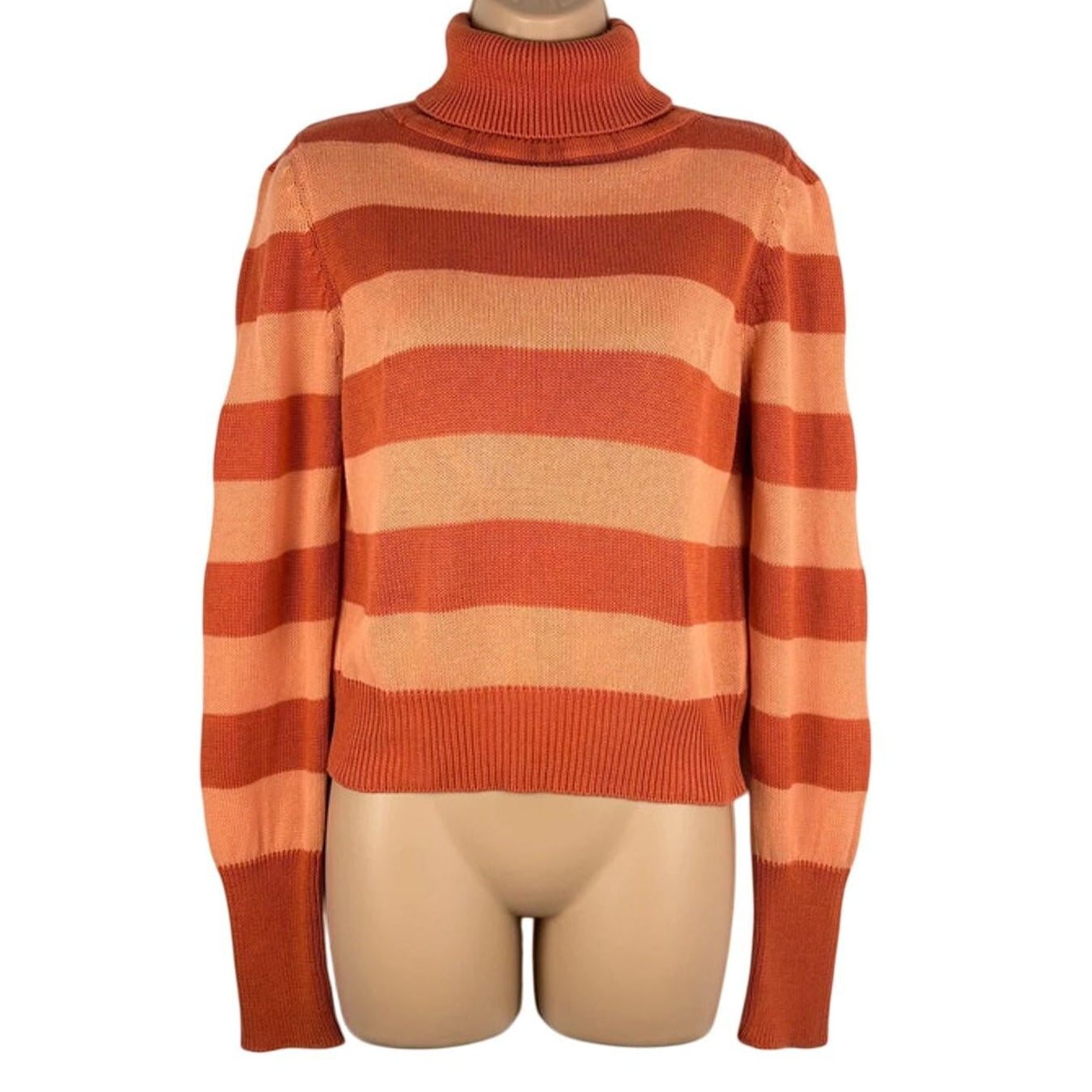 Orange and beige striped sweater on a mannequin against a white background