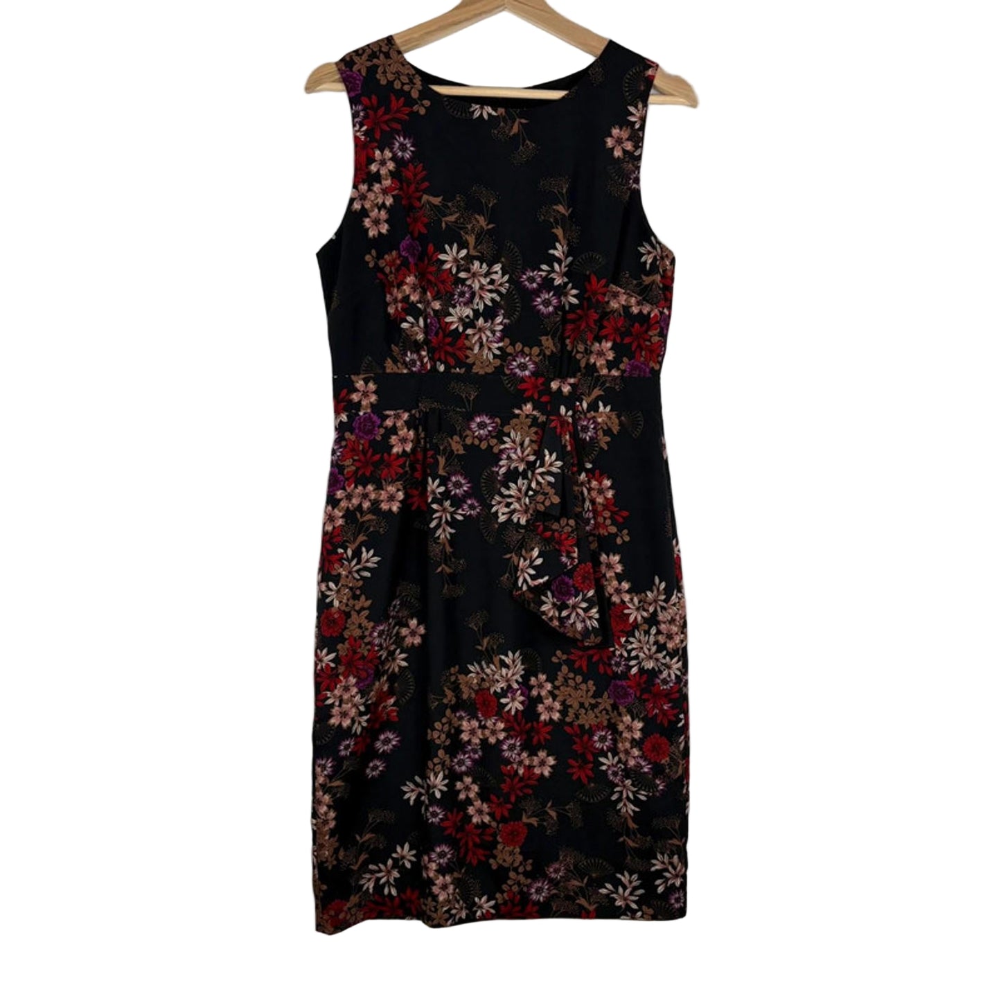 Black sleeveless dress with floral pattern on a hanger against a white background