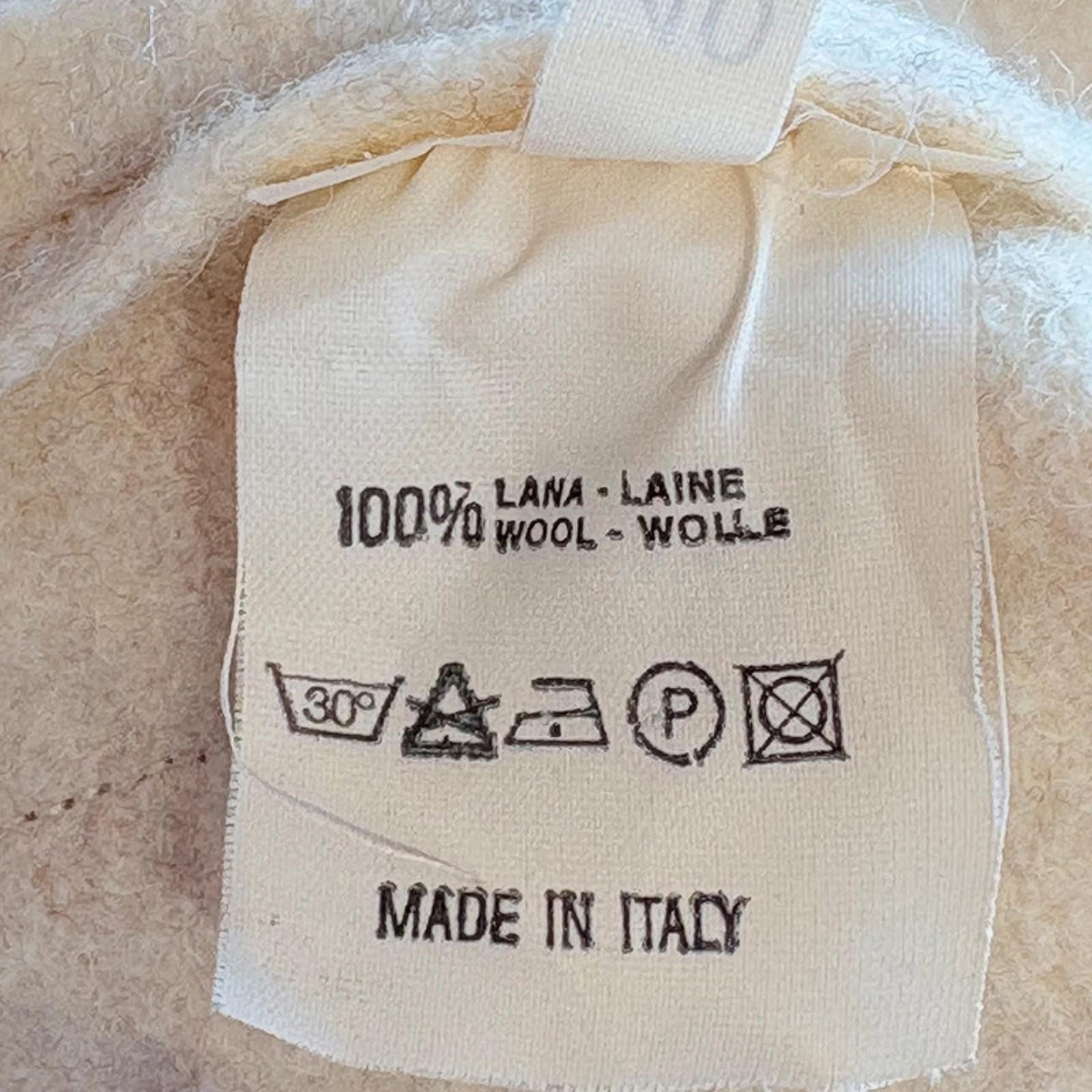 Wool label on a textured beige fabric background