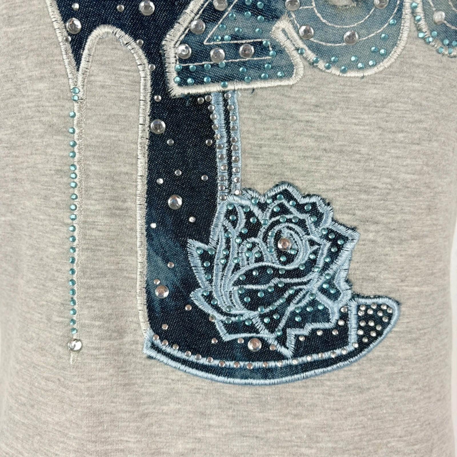 Embroidered cowboy boot with decorative elements on a gray background