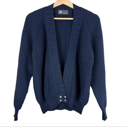 Blue knitted cardigan on a hanger against a white background