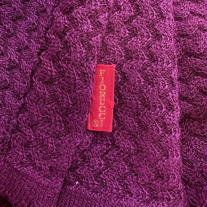 Close-up of a textured purple fabric with a red label featuring text.