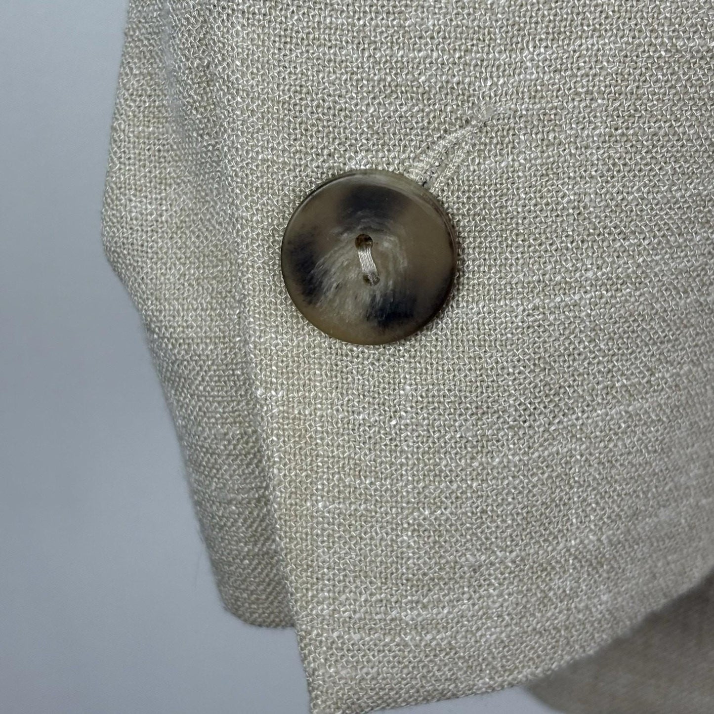 Close-up of a textured gray fabric surface with a button.