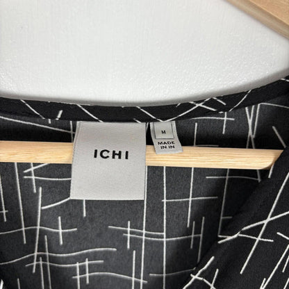 Close-up of a chair with 'ICHI' label and geometric patterned fabric.