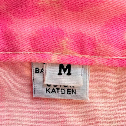 Close-up of a label on pink fabric with text 'M Katoen'.