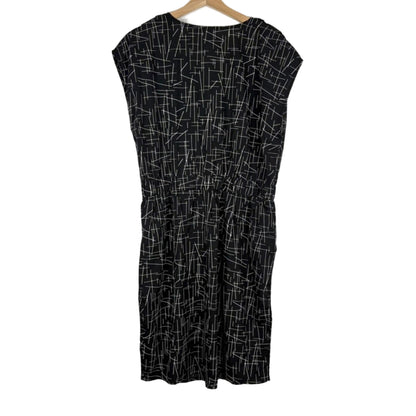 Black dress with white geometric pattern on a hanger against a white background