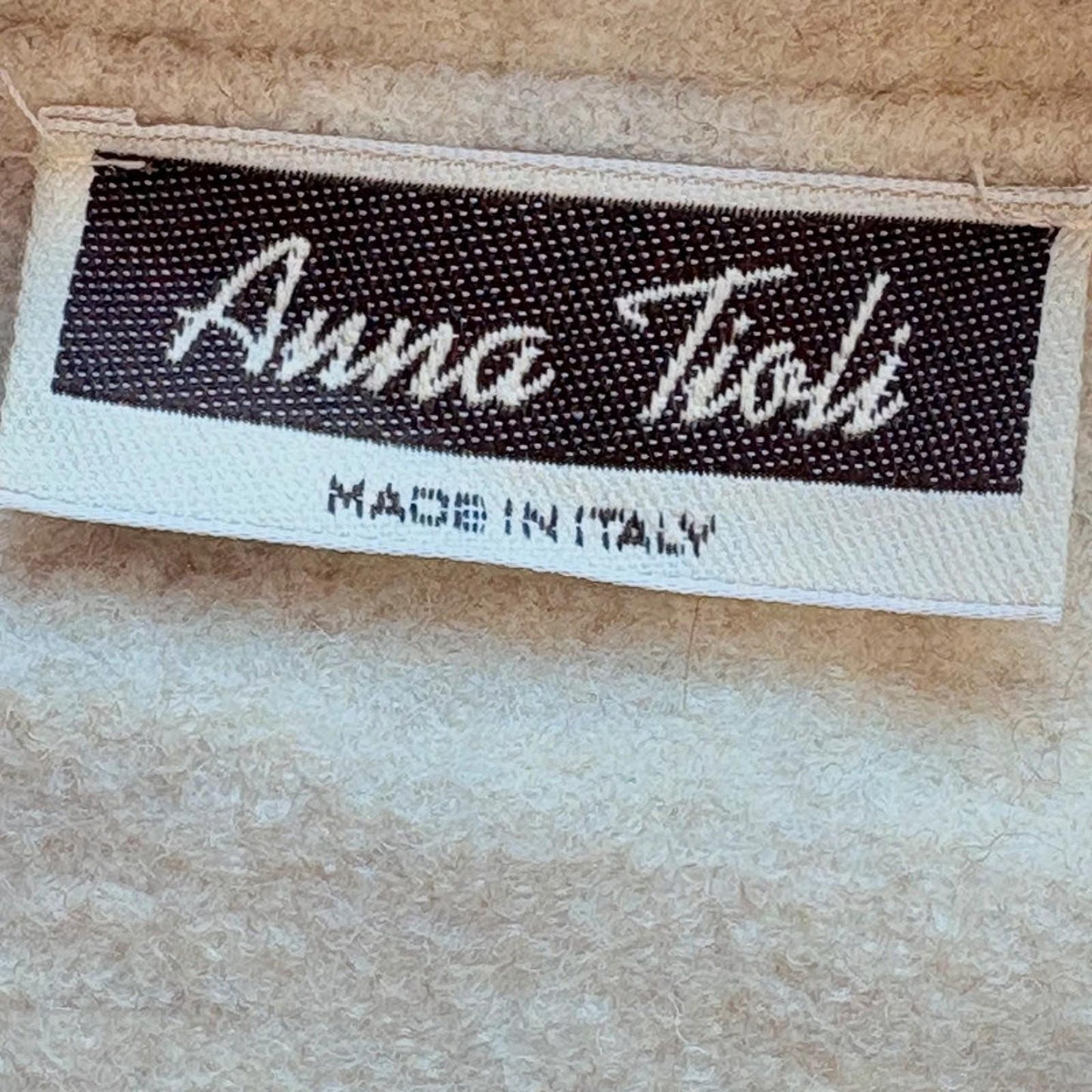 Label with 'Anna Tioli' branding and 'Made in Italy' text on a textured beige background