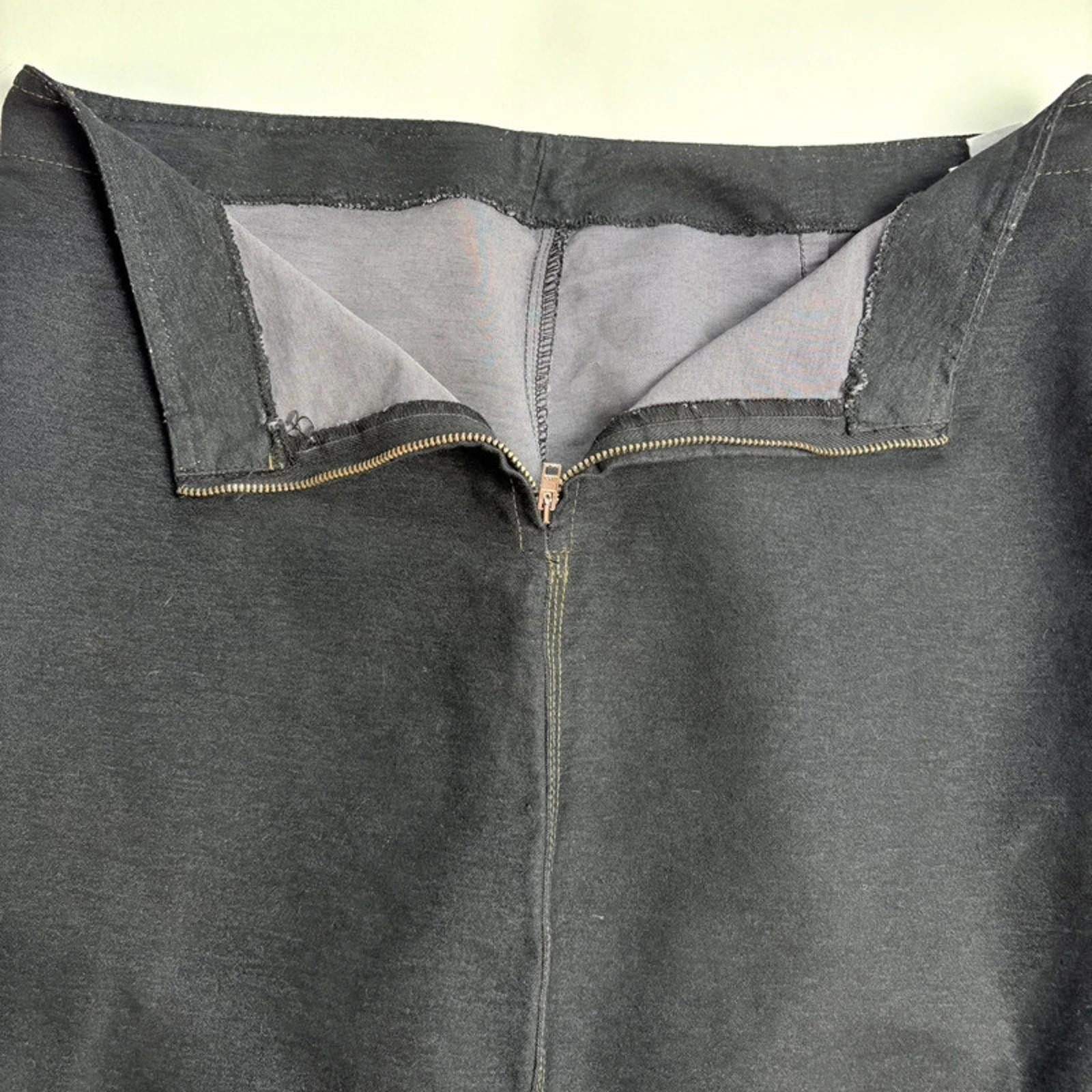 Close-up of a grey denim skirt with a zipper on a light background