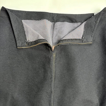 Close-up of a grey denim skirt with a zipper on a light background