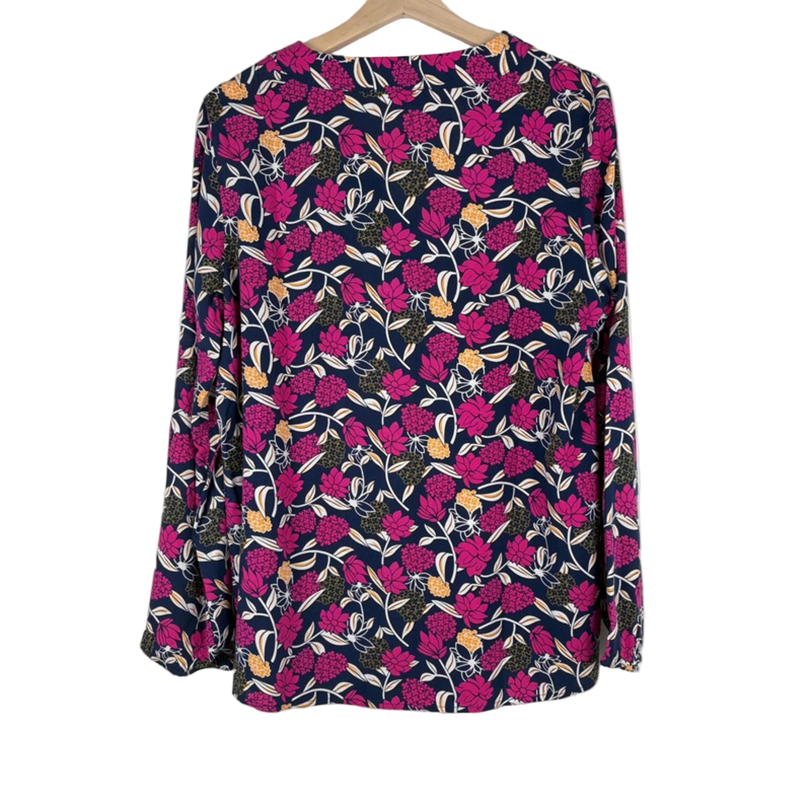 Floral patterned shirt on a hanger against a white background