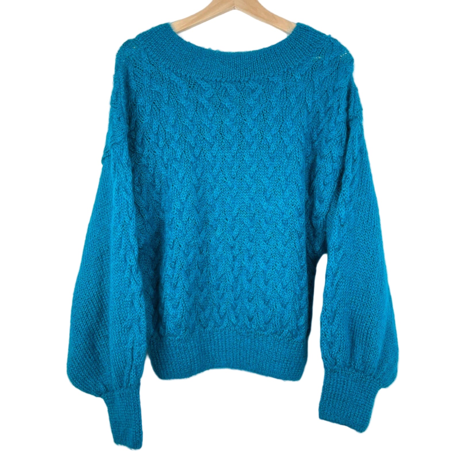 Blue knitted sweater on a wooden hanger against a white background