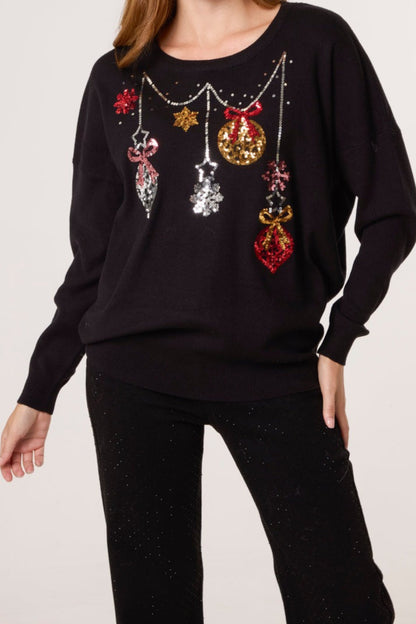 Black sweater with colorful Christmas ornament design on a plain background