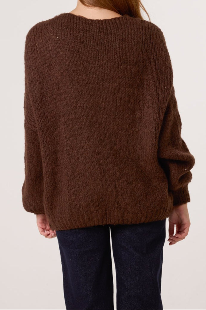 Brown sweater worn by a person on a plain background